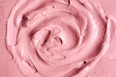 Yumuşak pembe kozmetik kil (rhassoul, yüz maskesi, yüz kremi, vücut sargısı) dokusu yakın, seçici odaklanma. Çember fırça darbeleriyle soyut arkaplan.    