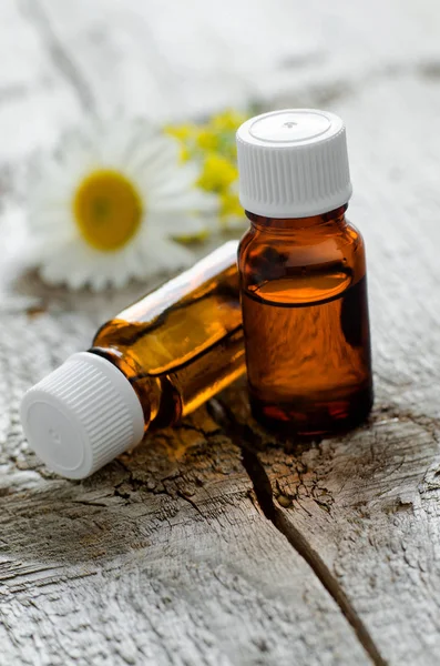 Due piccole bottiglie con oli essenziali sul vecchio fondo in legno. Ingredienti per aromaterapia, spa e fitoterapia. Copia spazio — Foto Stock