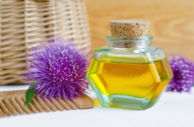 İçinde dulavrat yağı ve ahşap saç tarağı olan küçük bir şişe. Doğal saç bakım konsepti. Boşluğu kopyala