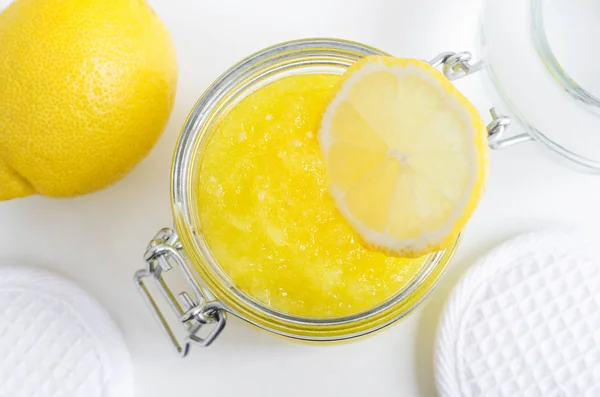 Homemade lemon facial mask (exfoliating sugar scrub) in the glass jar. DIY citrus beauty treatment and spa recipe. Top view, copy space. — Stock Photo, Image