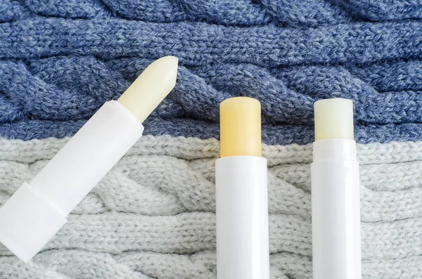 Three lip balms on the knitted background. Winter lip care stick — Stock Photo, Image