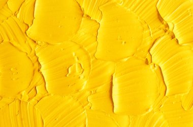 Sarı yüz maskesi (yüz kremi, vücut sargısı) dokusu yakın, seçici odaklanma. Fırça darbeleriyle soyut arkaplan.    