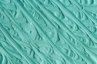 Açık mavi / yeşil bentonit yüz kil (maske, yüz kremi, vücut sargısı) dokusu yakın, seçici odaklanma. Fırça darbeleriyle soyut turkuaz arkaplan.  