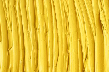 Sarı kozmetik yüz maskesi (krem, vücut scrub) doku yakın kadar seçici odak. Fırça darbeleri ile arka plan. 