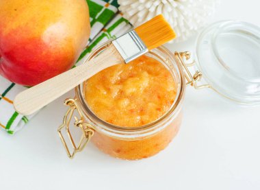 Cam kavanozda ev yapımı mango yüz maskesi (cilt temizleyici şeker yüz ve vücut fırçası). Fruit Diy güzellik ve spa tarifi. Üst görünüm, alanı kopyala 