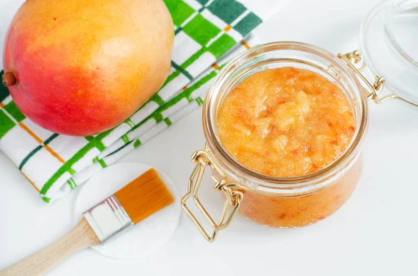 Domácí mango obličejová maska (odlupovací cukernatý obličej a tělo drhnutí) ve skleněné nádobě. Ovoce Diy kosmetické ošetření a lázeňské recept. Horní pohled, kopírovací prostor — Stock fotografie