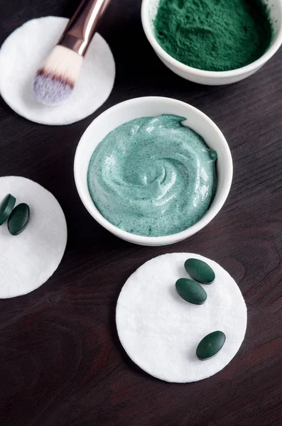 Spirulina and yogurt facial mask (body wrap) in the small white bowl. Natural beauty treatment and spa recipe. Close up, top view, copy space. — Stock Photo, Image