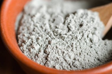 Kasede gri bentonit kil tozu. Yüz maskesi ve vücut ambalajı tarifi. Doğal güzellik tedavisi ve spa. Kil dokusu yakın çekim, seçici odaklanma.