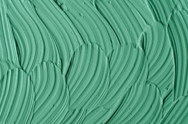 Yeşil kozmetik kil (yosun maskesi, yüz kremi, spirulina vücut ambalajı) dokusu yakın, seçici odaklanma. Fırça darbeleriyle soyut arkaplan. 