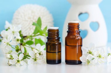 Gerekli yağı olan iki küçük cam şişe (tentür, infüzyon, parfüm). Beyaz çiçekler kapanıyor. Aromaterapi, spa ve bitkisel ilaç malzemeleri. Boşluğu kopyala. 