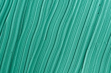 Yeşil kozmetik kil (yosun maskesi, yüz kremi, spirulina vücut ambalajı) dokusu yakın, seçici odaklanma. Fırça darbeleriyle soyut arkaplan.
