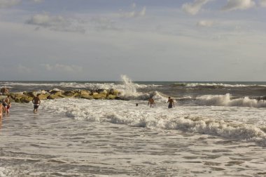 Marina di Massa rock yakınındaki kaba denizlerde banyo insanlar 