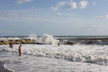 Marina di Massa, Toskana, İtalya için rock insanlar kaba denizlerde banyo yakınındaki 