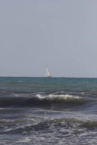 Rough seas in Marina di Massa, with a sailing boat — Stock Photo, Image