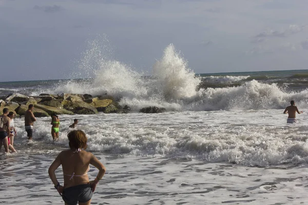 İnsanlar üzerinde ağır bir deniz sahil şeridi üzerinde 