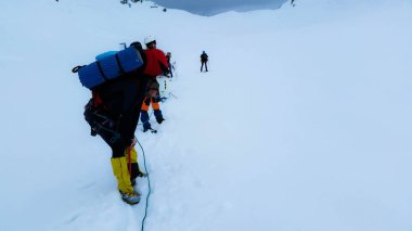 Yorgun tırmanışçılar Belukha dağına tırmanıyor..