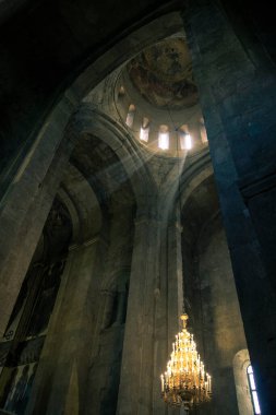 Pencerelerden güneş ışınları ve eski bir avize, Georgia 'daki kilise.