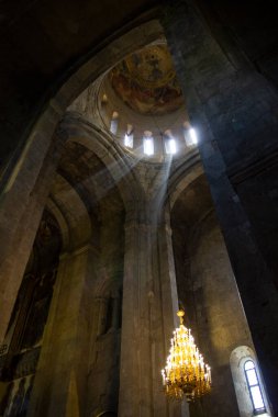 Pencerelerden güneş ışınları ve eski bir avize, Georgia 'daki kilise.
