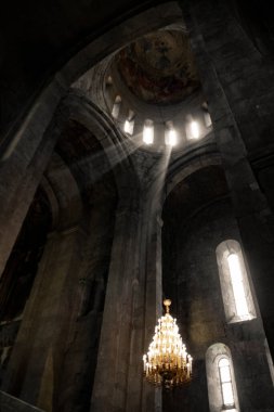 Pencerelerden güneş ışınları ve eski bir avize, Georgia 'daki kilise.