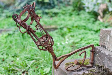 Bir mezarlığın paslı eski fener parçası.