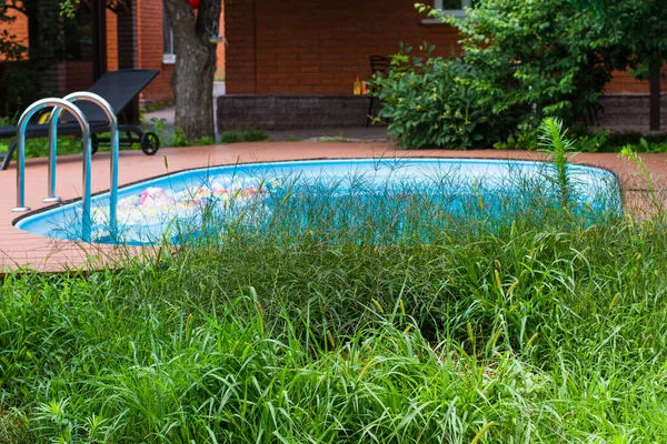 fragment of a private area with a pool and grass near the house