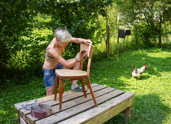 Vrouw Restaurateur Werkt Tuin Schuurpapier Herstelt Een Oude Stoel — Stockfoto