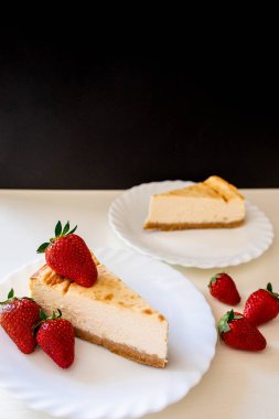 Beyaz tabakta ev yapımı çileklerle kaplı ev yapımı peynirli kek ve fotokopi alanı. Kendi kendine yetebilirlik kavramı. Sağlıklı beslenme. Temiz yemek. Tatillerde. Bahar geldi.