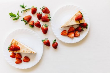 Beyaz tabakta çilek. Lezzetli cheesecake, biyolojik çilek ve nane yaprağı tasarımı manzarası. Yapması kolay tatlılar. Metin için yeri olan beyaz arkaplan. Babalar günün kutlu olsun. Tatillerde. Sevgililer Günü. Seni seviyorum.