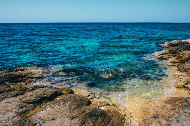 Turkuaz denizi ve kayalık kıyı şeridi olan körfeze bakın. Güzel deniz manzarası. Tatil havası başladı. Yaz zamanı. Kumsal zamanı. Kopyalama alanı olan turizm arkaplanı.