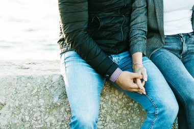 Genç ve mutlu evli çift güneş ışınlarıyla gün batımında deniz kenarında oturuyorlar. Hayat tarzı balayı geçmişi, fotokopi alanı. Romantik bir kavram. Erkek ve kadın el ele tutuşuyor. Samimi anlar. Yavaş yaşam.