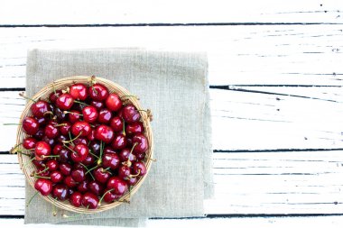 Kiraz. Beyaz arkaplandaki kırsal kasede taze kirazlar ve metin için boş alan.