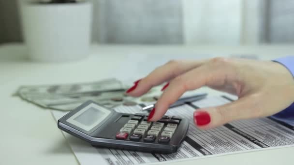 Femme utilise une calculatrice et l'éteint. Vue latérale rapprochée des mains féminines 