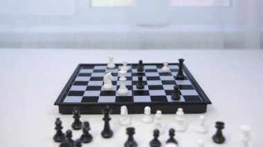 Satranç oyunu. Siyah piyon beyaz papazı yener. Adam kazanan bir hamle yapıyor.