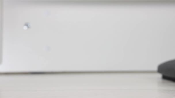 Close-up de um aspirador de pó preto limpeza escova pisos brancos — Vídeo de Stock