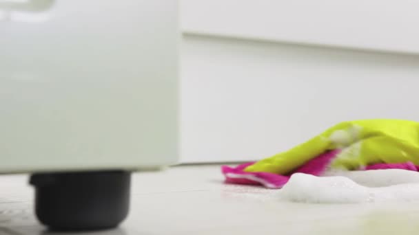 Close-up de mãos em luvas amarelas limpando a espuma de limpeza do chão — Vídeo de Stock