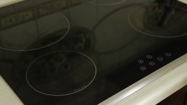 Vrouw zet op een zwart fornuis een traditionele ovenschotel — Stockvideo