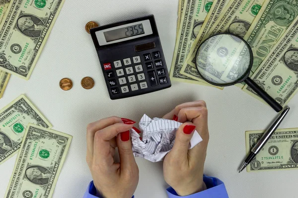 Beyaz bir masaüstü üzerinde mali verileri olan kadın elleri buruşturma sayfası