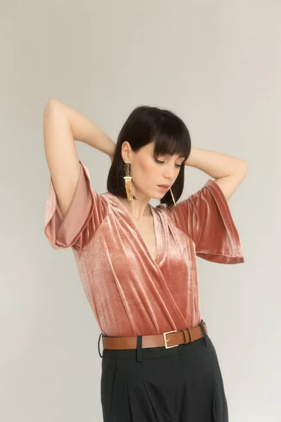 Pembe kadife bluzlu muhteşem kadının stüdyo portresi.