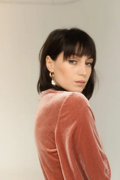 Pembe kadife bluzlu muhteşem kadının stüdyo portresi.