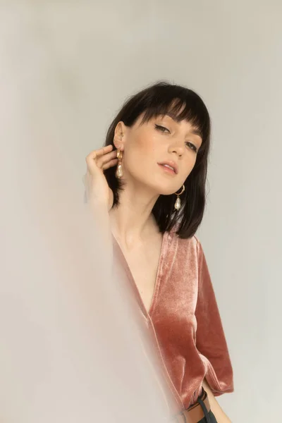 Pembe kadife bluzlu muhteşem kadının stüdyo portresi.