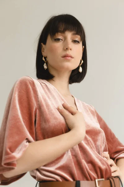 Pembe kadife bluzlu muhteşem kadının stüdyo portresi.