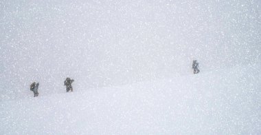 Yolcuları kar blizzar dağlarında trekking grubu