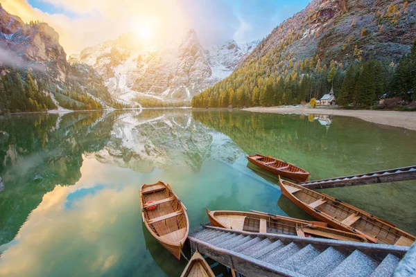 Fantastic autumn landscape with boats on the lake with sunrise o