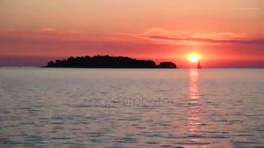 Adadan izler ve güneş arka plan üzerinde deniz boyunca yüzen bir yelkenli tekne ile inanılmaz bir büyülü manzara