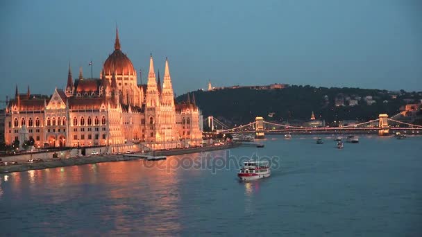 議会とランプの光に夜のブダペスト ハンガリー ヨーロッパのドナウ川にかかる橋の美しい景色 — ストック動画