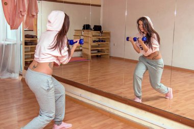 Genç güzel kız Fitness Spor salonu bef dumbbells ile yapıyor