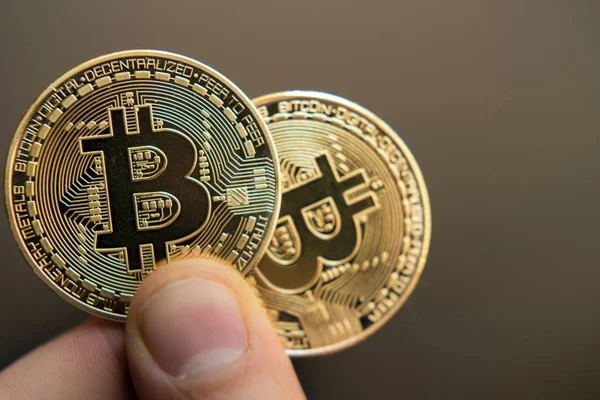 Två bitcoins i hand (investeringar, jagaändringen, rise, minskad, — Stockfoto