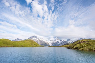 A magical landscape with a lake and clouds  in the mountains in  clipart