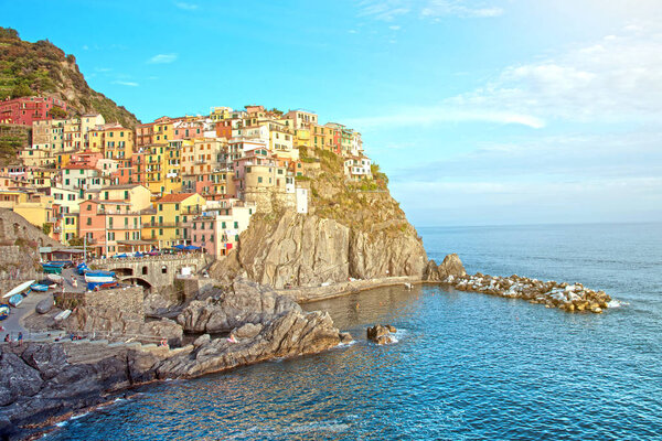 Charming beautiful landscape with bright colored houses on the rock on the seafront of Manarola in Cinque Terre, Liguria, Italy, Europe in sunlight