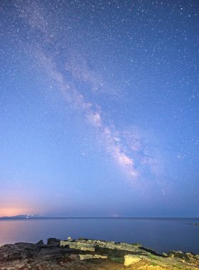 büyülü mistik güzel büyüleyici manzara dalgalar ve yıldızlar ve Samanyolu arka plan karşı kıyısında deniz ortasında taşlar ile. (meditasyon, antistress, gevşeme - kavram)